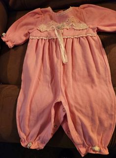 Here's another item from the baby clothes I recently acquired. It's a pretty pink one-piece romper, adorned with rosebuds on the sleeves and the cuffs. All the snaps are intact and they all work. It's a size 6-9 months item, made by Baby Kisses, in cotton and polyester. The romper is in very good vintage condition, with no rips or stains.  Please check my other listings for more vintage baby clothes. Pink Onesie For Bedtime In Spring, Pink Onesie For Bedtime And Spring, Pink Cotton Baptism Onesie, Baby Pink Romper, Baby Kiss, Vintage Baby Clothes, Pink One Piece, Baby Rompers, Girls Clothing Sets