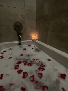 a bathtub filled with water and rose petals