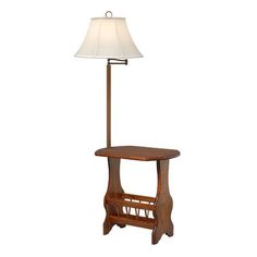 a lamp that is on top of a wooden table with a white shade over it