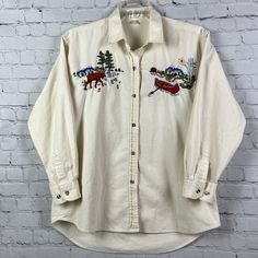 Vtg Casey Coleman Embroidered Cotton Moose Canoe Button Up Shirt Outdoor Womens. Welcome To Project Perseverance! Brand: Casey Coleman Size: See Measurements Condition: Great Pre-Owned Condition Couple Tiny Marks, See Photos Color/Pattern: Ivory/Cream With Beautiful Embroideries On Chest. Mountains, Lake, Cabin, Moose, Trees, Canoe. Measurements: - Pit To Pit (Across Chest): ~23.25” -Sleeve (Shoulder To Cuff): ~20.75” Thank You For Shopping With Project Perseverance! Condition Notes And Buying P Retro Embroidered Button-up Top, Vintage Embroidered Fall Shirt, Vintage Embroidered Button-up Shirt, Lake Cabin, Beautiful Embroidery, Photo Colour, Button Up Shirt, Cream White, Shoulder Sleeve