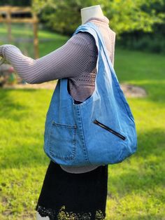 This large hobo bag is very spacious. It's made with a light-colored upcycled denim with a pretty purple cotton liner. The single strap is extra wide for comfort.  There is a large zippered pocket on the outside of the bag, along with a regular pocket. There are also 2 small vertical pockets on the side of the exterior. There is a large zippered pocket inside. Cheap Casual Denim Hobo Bag, Cheap Denim Blue Hobo Bag For Daily Use, Cheap Blue Hobo Bag With Pockets, Cheap Denim Blue Hobo Bag For Women, Hobo Bag From Old Jeans Free Pattern, Cheap Blue Denim Hobo Bag, Cheap Denim Hobo Tote Bag, Cheap Blue Hobo Bag With Handles, Denim Hobo Bag