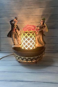 a small figurine sitting on top of a table next to a candle holder