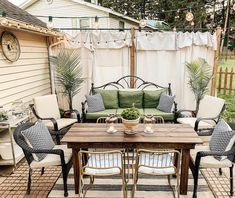 an outdoor patio with furniture and potted plants on the table in front of it