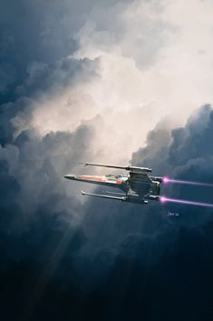 an airplane flying in the sky with clouds behind it and bright beams coming from underneath