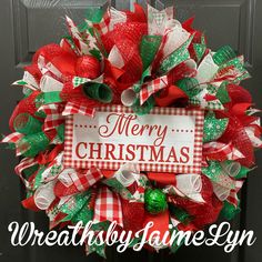 a christmas wreath with the words merry christmas written in red, green and white on it