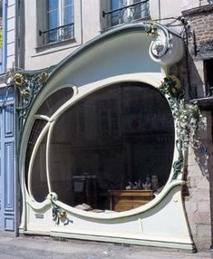 a large round mirror sitting on the side of a building