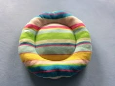 a multicolored cat bed is hanging on the wall