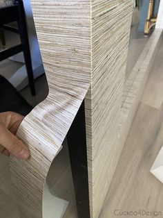 a person is holding the edge of a piece of wood