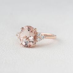 an oval morganite and diamond ring on a white surface