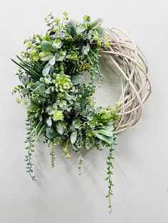 a wreath hanging on the wall with greenery