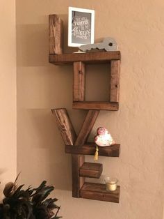 a shelf made out of wooden pallets on the wall next to a potted plant