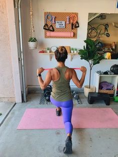 a woman is doing exercises on a pink mat in her home gym with exercise equipment