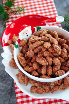 a white bowl filled with cat food on top of a red and white checkered table cloth