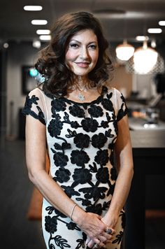 a woman in a black and white dress posing for the camera with her hand on her hip