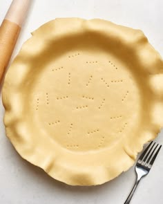 an uncooked pie crust on a table with a fork