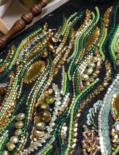 beaded and sequins are displayed on a black cloth with wooden beads in the background