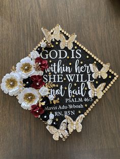 a graduation cap decorated with flowers and bible verse on the front, sitting on a table