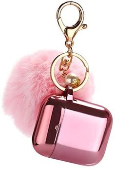 a pink purse key chain with a fur ball hanging from it's center loop