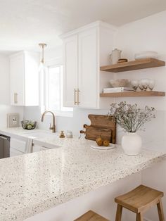 a kitchen with white counter tops and wooden stools