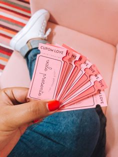 a person holding up pink tickets in their hand with the words coupon love written on them