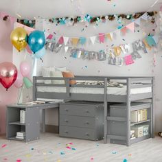 there is a bed with a desk underneath it and balloons on the wall behind it