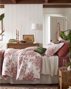 a bed with red and white comforters in a room