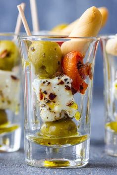 olives and feta shooters in small glasses with toothpicks sticking out of them