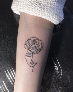 a woman's arm with a rose tattoo on the left side of her arm