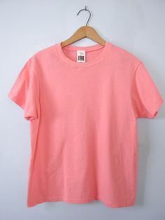 One vintage 1990's plain peach pink tee shirt, men's size small * Crew neckline. * Plain shirt. * Color scheme: pink with peach tones / salmon. | CONDITION | A+. Gently used vintage item. | BRAND | Fruit of the Loom. Made in Honduras. | SIZE | Marked as a child's Large (USA). Fit would be similar to a men's Small or XSmall. PLEASE compare the measurements below to a similar item that fits you for the best sizing! ~ Garment laying flat. Double measurements where applicable. ~ Shoulder width: 15.5 Basic Pink Pre-shrunk T-shirt, Basic Plain Pink T-shirt, Basic Pink Plain T-shirt, Basic Pink Crew Neck T-shirt, Heather Peach Cotton Short Sleeve T-shirt, Heather Peach Short Sleeve Cotton T-shirt, Heather Peach Cotton T-shirt, Peach Relaxed Fit Short Sleeve T-shirt, Casual Plain Pink T-shirt