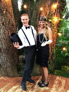 a man and woman are dressed up for a masquerade party in front of trees