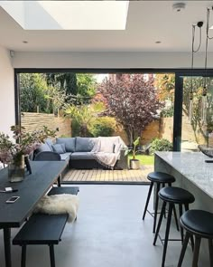 a living room filled with furniture next to a large glass window covered in lots of windows