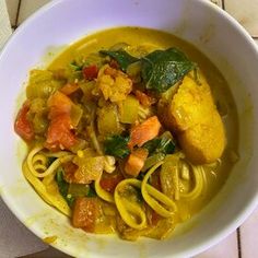 a white bowl filled with pasta and vegetables