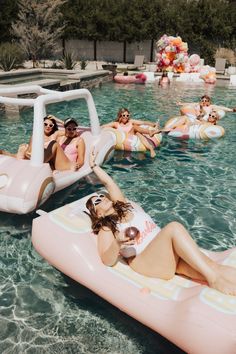 a group of people floating on inflatable rafts in a pool with floats