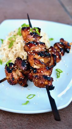 chicken and rice skewers on a plate with chopsticks