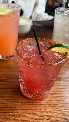 two cocktails sitting on top of a wooden table