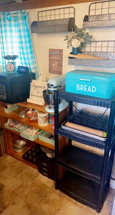 a blue bread warmer sitting on top of a wooden shelf next to other kitchen items