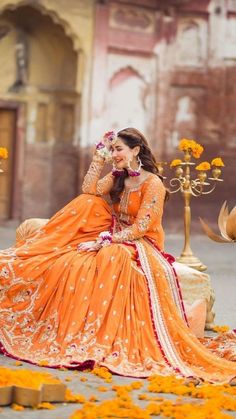 a woman in an orange dress sitting on the ground