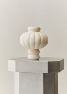 a white vase sitting on top of a table