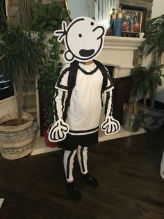 a person in a costume standing on a wooden floor next to a fireplace and potted plant