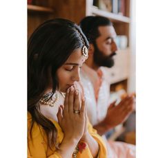 two people are sitting and praying together