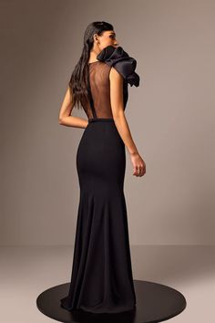 a woman in a black dress is looking back