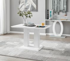 a white table with plates and cups on it in front of a gray carpeted floor