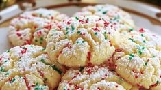 a white plate topped with cookies covered in sprinkles on top of a table