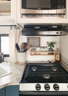 a stove top oven sitting inside of a kitchen next to a microwave above it's burner