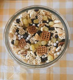 a glass bowl filled with lots of different types of cereal and marshmallows