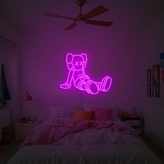 a neon pink teddy bear sitting on top of a bed in a room with purple walls