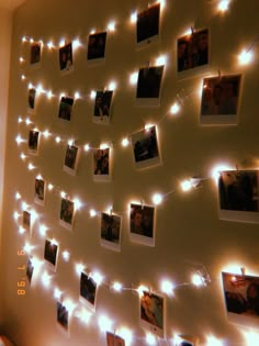 several polaroid pictures are hung on a wall with string lights