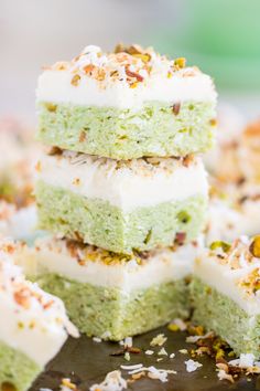 several pieces of green cake with white frosting and sprinkles on top