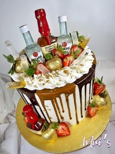 a cake decorated with chocolate, strawberries and liquor bottles