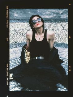 a woman sitting on the ground wearing sunglasses